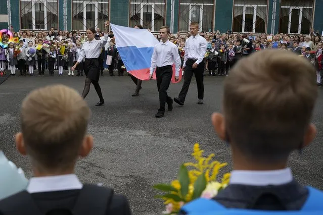 Pupils carry Russian flag during a ceremony marking the start of classes at a school as part of the traditional opening of the school year known as “Day of Knowledge” in St. Petersburg, Russia, Friday, September 1, 2023. (Photo by Dmitri Lovetsky/AP Photo)