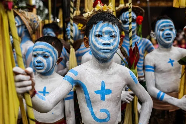 Boys body-painted as scary mythical creatures symbolizing the balance between darkness and light wait to practice their Hindu ritual, the Ngerebeg tradition, seeking a better life by neutralizing negative influences on people and the universe in Tegalalang on September 6, 2023. (Photo by Garry Lotulung/AFP Photo)