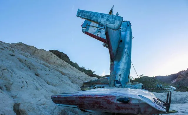 Images of an American ghost town that was home to gold mines and features a plane which crashed during the filming of 3000 Miles to Graceland starring Kevin Costner and Kurt Russell reveal the remnants of the once thriving location. An assortment of rusted vehicles which include a canary yellow bus, caravans and cars have all been left behind in the desert. Other pictures of Nelson, Nevada show its desolate surroundings with only a couple of houses and museums scattered around the area. In one shot, a derelict petrol pump stands still after making its final sale years ago. The stunning photographs were taken by an American photographer known as Abandoned Southeast on a visit to Nelson, Nevada. The area was called Eldorado by the Spaniards who made the original discoveries of gold in the town. The notorious Techatticup gold and silver mine which was associated with crime and murders ran in the area from 1861 to 1942. It was the richest mine in Southern Nevada. (Photo by Abandoned Southeast/Mediadrumworld.com)