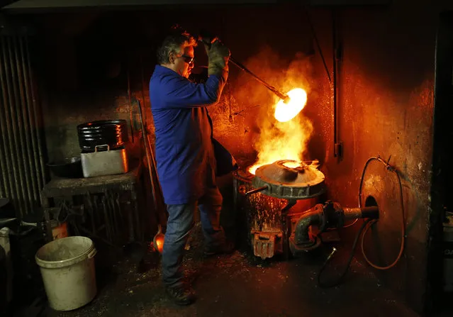 Serge Huguenin of the Blondeau foundry removes the cover of the oven during the preparation of the bronze bells in La Chaux-de-Fonds, Switzerland January 21, 2016. (Photo by Denis Balibouse/Reuters)