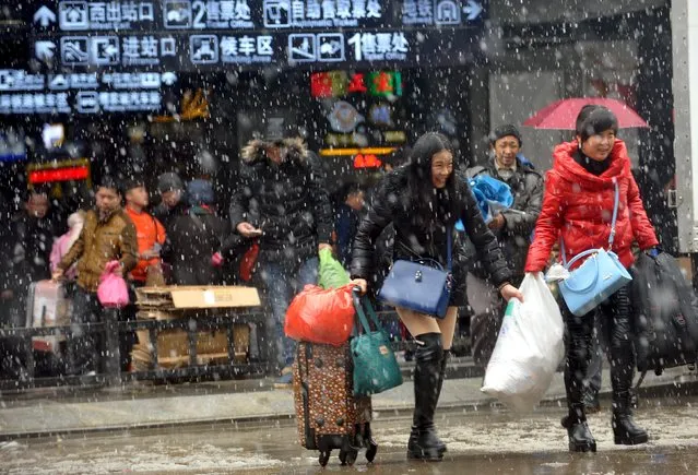 People carrying luggages leave a railway station in snow in Wuhan, Hubei province, January 31, 2016. According to traffic police, over 2.9 billion trips will be made around China during the 40-day Spring Festival travel rush started on January 24. (Photo by Reuters/Stringer)