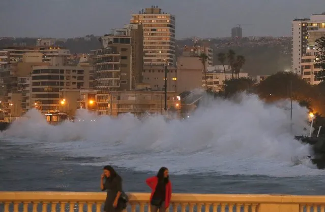 Tourists watch high waves of the Pacific Ocean pounding the coast in Vina del Mar city, Chile February 4, 2016. (Photo by Rodrigo Garrido/Reuters)