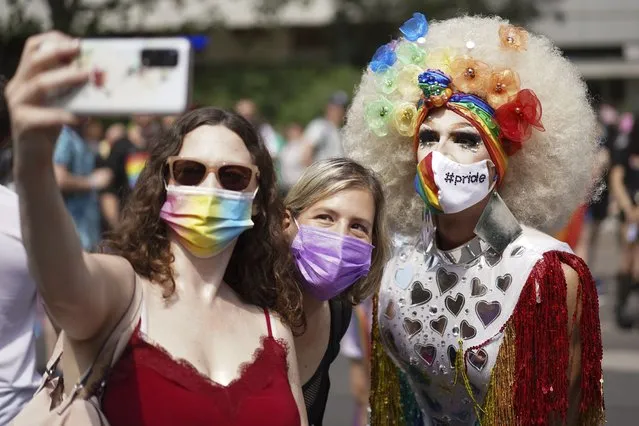 Revelers take part in the Christopher Street Day (CSD) parade, in Berlin, Saturday, July 24, 2021. The official motto of the CSD is “Save our Community – save our Pride”.  (Photo by J'rg Carstensen/dpa via AP Photo)