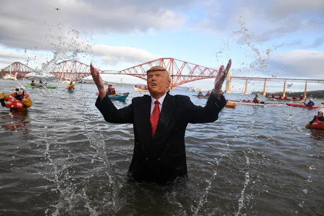 Members of the public join New Year swimmers, many in costume, in front of the Forth Rail Bridge during the annual Loony Dook Swim in the River Forth on January 1, 2019 in South Queensferry, near Edinburgh, Scotland. Tens of thousands of people gathered last night in Edinburgh and other events across Scotland to see in the New Year at Hogmanay celebrations. (Photo by Jeff J, Mitchell/Getty Images)