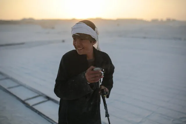 In this Wednesday, March 18, 2015 photo, a young worker smiles during a tea break at sunrise in the desert of Minya, southern Egypt. Some children as young as 10 years old work in the quarries to help their families, risking injury and sometimes death. (Photo by Mosa'ab Elshamy/AP Photo)