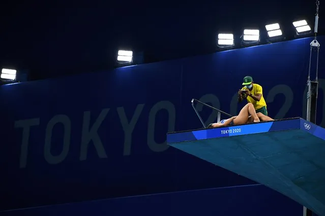 An athlete has her photo taken on the diving board at the Tokyo Aquatics Centre, during the Tokyo 2020 Olympic Games in Tokyo, Japan, August 1, 2021. (Photo by Clodagh Kilcoyne/Reuters)