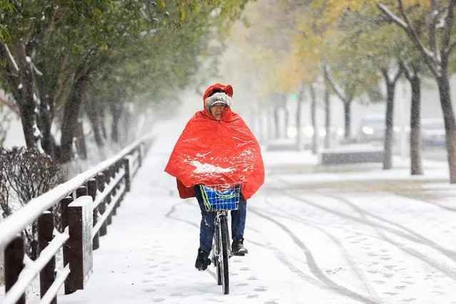This photo taken on November 6, 2023 shows a person riding bicycle as it snows in Shenyang, in China's northeastern Liaoning province. (Photo by AFP Photo/China Stringer Network)