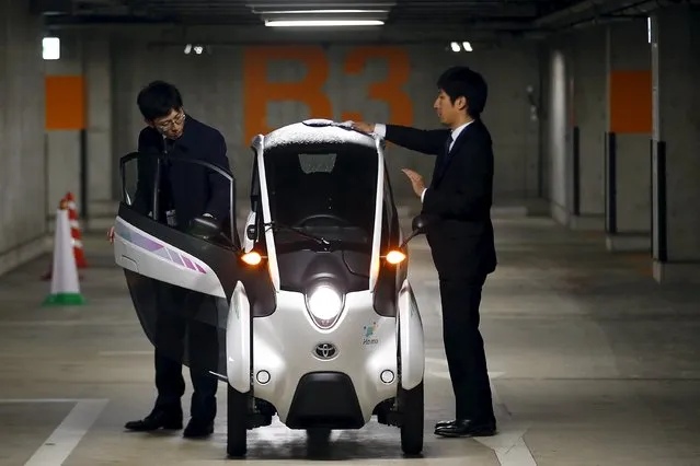 Staff members clean a Toyota i-Road electric vehicle in Tokyo April 9, 2015. (Photo by Thomas Peter/Reuters)