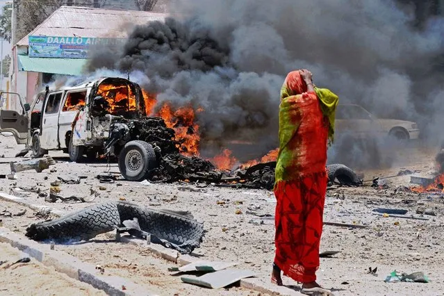 A Somali woman reacts on March 18, 2013 near the site of a car bomb in central Mogadishu. (Photo by Mohamed Abdiwahab/AFP Photo)