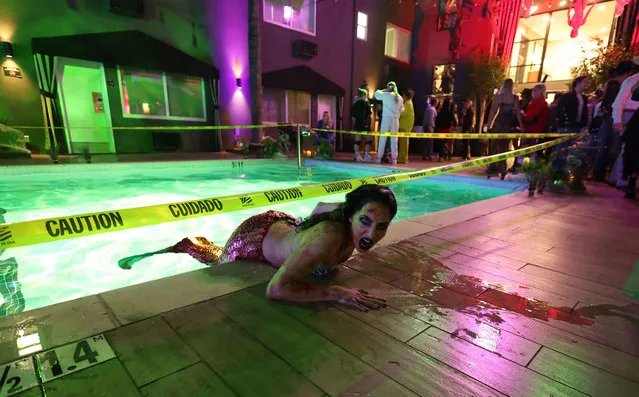 A person dressed as a zombie mermaid poses for a photo as she interacts with patrons at the Haunted Hotel Takeover Halloween party at hotel Ziggy in West Hollywood, California, U.S., October 29, 2022. (Photo by Mario Anzuoni/Reuters)