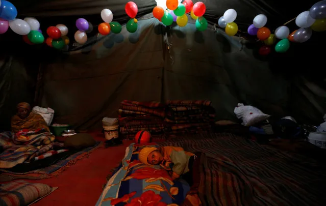 A child rests in a government shelter for homeless people to escape the cold in Delhi, India January 16, 2017. (Photo by Cathal McNaughton/Reuters)