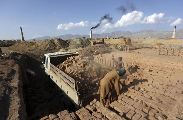 Afghan day laborers load bricks on a truck at a brick factory on the outskirts of Kabul, Afghanistan, Monday, April 20, 2015. (Photo by Rahmat Gul/AP Photo)