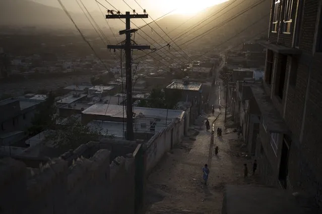 Afghans walk in an alleyway as the sun sets in Kabul, Afghanistan, Thursday, September 16, 2021. (Photo by Felipe Dana/AP Photo)