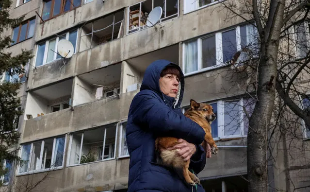 A local resident holds her dog as she stands near her apartment building damaged during a Russian missile strike, amid Russia's attack on Ukraine, in Lviv, Ukraine on February 15, 2024. (Photo by Roman Baluk/Reuters)