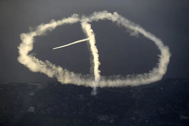 In this May 2, 2015 photo, skywriter Nathan Hammond works on a peace sign as he writes messages of hope and love over New Orleans, during the New Orleans Jazz & Heritage Festival. (Photo by Gerald Herbert/AP Photo)