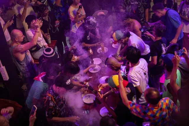 People smoke out of bongs during a speed contest to finish 3 grams, at the Green Party in Bangkok, Thailand, on October 7, 2023. (Photo by Jorge Silva/Reuters)