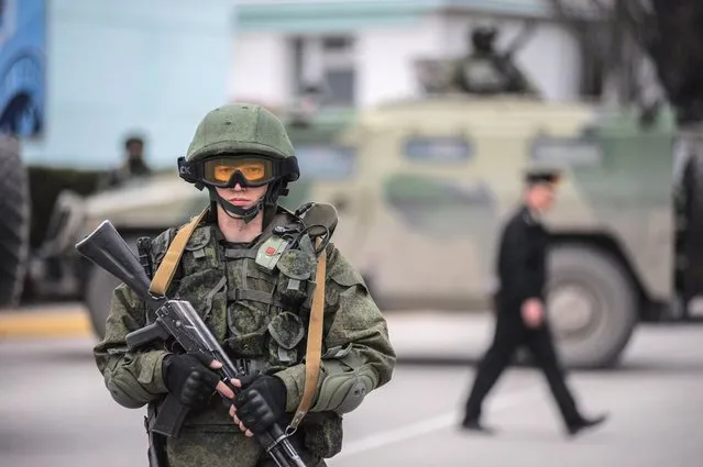 A gunman in unmarked uniform stands guard as troops take control the the Coast Guard offices in Balaklava on the outskirts of Sevastopol, Ukraine, Saturday, March 1, 2014. (Photo by Andrew Lubimov/AP Photo)