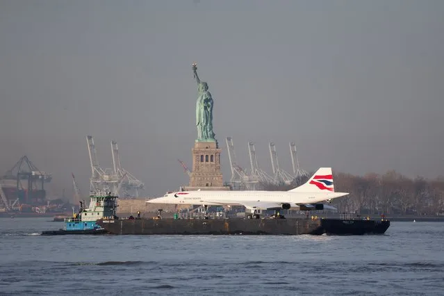 The Concorde supersonic jet is carried on a barge along the Hudson River past the Statue of Liberty returning to the Intrepid Sea, Air and Space museum in New York, on March 14, 2024. (Photo by Brendan McDermid/Reuters)