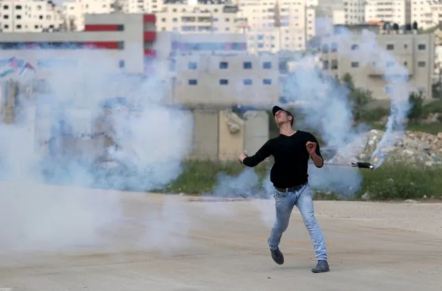 A Palestinian protester uses a sling to return a tear gas canister fired by Israeli troops during clashes at a protest marking Land Day, near Israel's Ofer Prison near the West Bank city of Ramallah March 30, 2016. March 30 marks Land Day, the annual commemoration of protests in 1976 against Israel's appropriation of Arab-owned land in the Galilee. (Photo by Mohamad Torokman/Reuters)