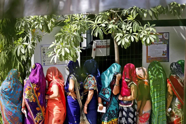 Indian women stand in queues to cast their votes in the seventh and final phase of national elections, on the outskirts of Varanasi, India, Sunday, May 19, 2019. (Photo by Rajesh Kumar Singh/AP Photo)