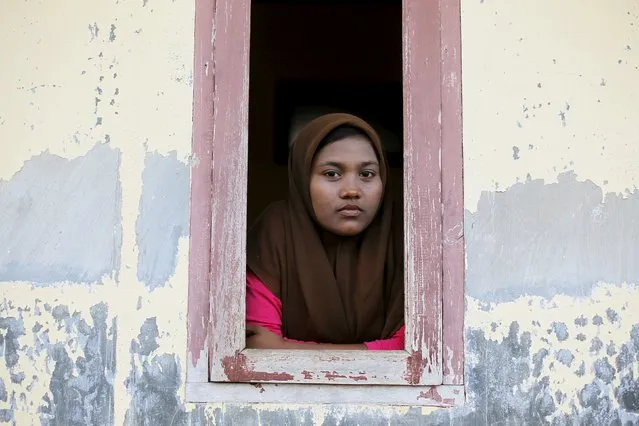 A Rohingya migrant woman, who arrived in Indonesia by boat, looks from a window of a shelter inside a temporary compound for refugees in Kuala Cangkoi village in Lhoksukon, Indonesia's Aceh Province, May 17, 2015. (Photo by Reuters/Beawiharta)