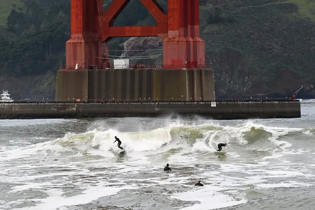 A view of men surfing under the Golden Gate Bridge during rainy weather in San Francisco, California, United States on February 20, 2024. (Photo by Tayfun Coskun/Anadolu via Getty Images)