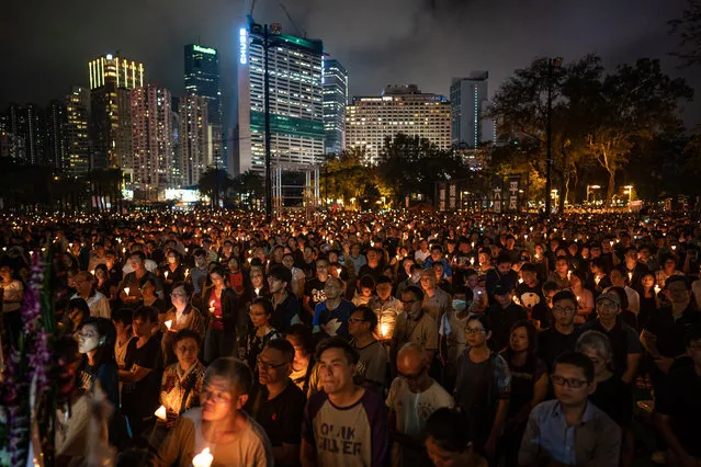 People hold candles as they take part in a candlelight vigil at Victoria Park on June 4, 2019 in Hong Kong, China. As many as 180,000 people are expected to attend a candlelight vigil in Hong Kong on Tuesday during the 30th anniversary of the Tiananmen Square massacre as commemorations took place in cities around the world on June 4 to remember those who died when Chinese troops cracked down on pro-democracy protesters. Thirty years ago, the People's Liberation Army opened fire and killed from hundreds to thousands of protesters in Beijing after hundreds of thousands of students and workers gathered in Tiananmen Square for weeks to call for greater political freedom. No-one knows for sure how many people were killed as China continues to censor any coverage or discussion of the event that takes place during the anniversary. (Photo by Anthony Kwan/Getty Images)