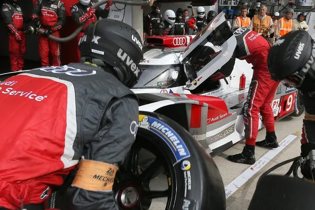 Mechanics changes the wheels of the Audi R18 E-TRON Quattro No9 driven by Filipe Albuquerque of Portugal, Marco Bonanomi of Italy and Rene Rast of Germany during a stop in the pits during the 83rd 24-hour Le Mans endurance race, in Le Mans, western France, Saturday, June 13, 2015. (AP Photo/David Vincent)