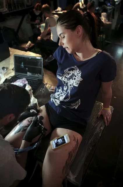 An artist works on a tattoo on a woman during the second International Tattoo Festival in Sochi, Russia, April 23, 2016. (Photo by Kazbek Basayev/Reuters)