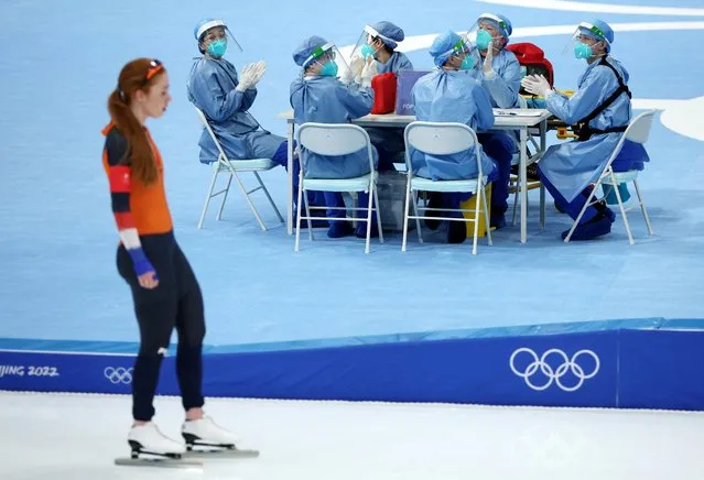 Medical staff react as Antoinette De Jong of the Netherlands skates past them after competing in the Women's Speed Skating 3000m at National Speed Skating Oval in Beijing, China on February 5, 2022. (Photo by Phil Noble/Reuters)