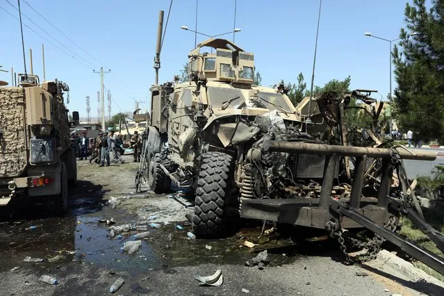 A destroyed armored vehicle remains at the site of a suicide attack on a NATO convoy in Kabul, Afghanistan, Tuesday, June 30, 2015. (Photo by Rahmat Gul/AP Photo)