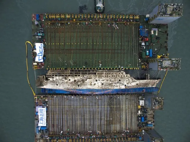 A salvage team works on raising the sunken Sewol ferry in the waters near Jindo, South Korea, 24 March 2017. The South Korean government is attempting to salvage the ferry that sank near Jindo on 16 April 2014, killing at least 295 people, with nine still missing, who were mostly high school students on a school excursion. (Photo by Lee Myeong-Ik/EPA)