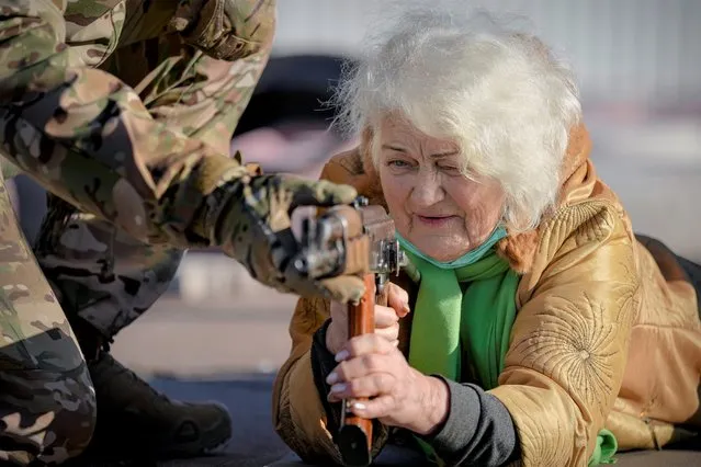 Valentyna Konstantynovska, 79 years-old, holds a weapon during basic combat training for civilians, organized by the Special Forces Unit Azov, of Ukraine's National Guard, in Mariupol, Donetsk region, eastern Ukraine, Sunday, February 13, 2022. The United States is evacuating almost all of the staff from its embassy in Kyiv as Western intelligence officials warn that a Russian invasion of Ukraine is increasingly imminent. (Photo by Vadim Ghirda/AP Photo)