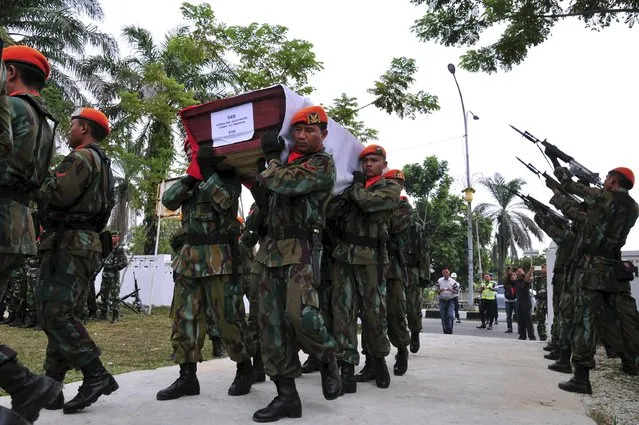 Members of the Indonesian Air Force carry the coffin of Sergeant Sugiyanto, who was killed in the crash of an Air Force transport plane in Medan, at a cemetery in Pekanbaru, Riau, Indonesia July 2, 2015 in this photo taken by Antara Foto. (Photo by F. B. Anggoro/Reuters/Antara Foto)