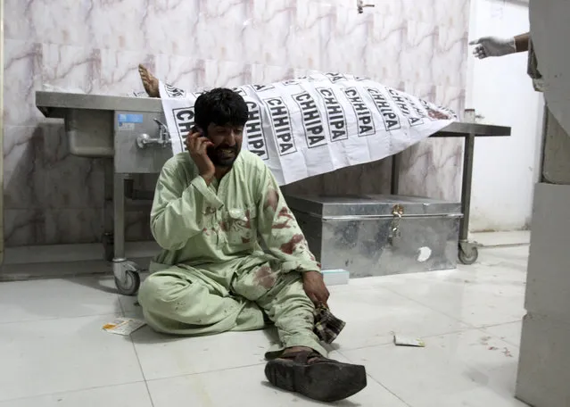 A man uses his phone to inform a family member about a death from a bombing, at a hospital in Quetta, Pakistan, Tuesday, July 30, 2019. Police in Pakistan say a roadside bomb struck a security vehicle in the southwestern city of Quetta, killing at least four people. (Photo by Arshad Butt/AP Photo)