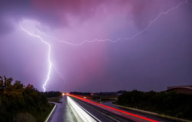 Lightning flashes through the sky over the A9 highway near Allershausen, southern Germany, on July 8, 2015. (Photo by Marc Mueller/AFP Photo)