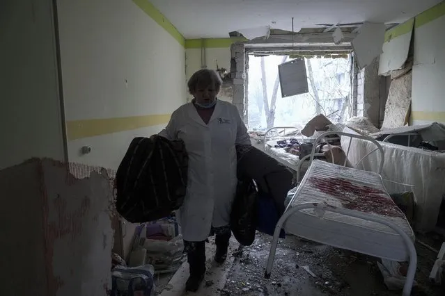 A medical worker walks inside of the damaged by shelling maternity hospital in Mariupol, Ukraine, Wednesday, March 9, 2022. A Russian attack has severely damaged a maternity hospital in the besieged port city of Mariupol, Ukrainian officials say. (Photo by Evgeniy Maloletka/AP Photo)