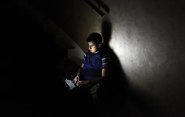 A member of the media works on a staircase at the Rixos hotel during a power cut in Tripoli, Libya, August 22, 2011. (Photo by Paul Hackett/Reuters)