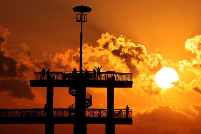 Revellers celebrate the sunrise during the July Morning festival at the pier of Burgas, on the Black Sea coast, Bulgaria on July 1, 2024. The festival dates back to the late 1970s and early 1980s when for some it was believed to be a form of protest against the Communist rule in the country, mainly attracting followers of the hippie counterculture of the 1960s. (Photo by Spasiyana Sergieva/Reuters)