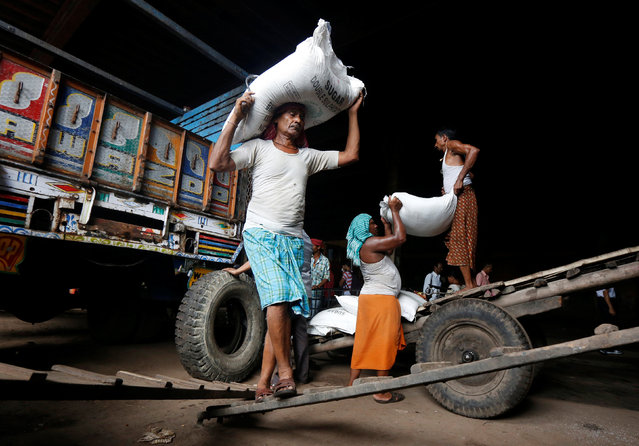 Labourer carry sacks filled with sugar to load them onto a supply truck at a wholesale market in Kolkata, India May 16, 2016. (Photo by Rupak De Chowdhuri/Reuters)