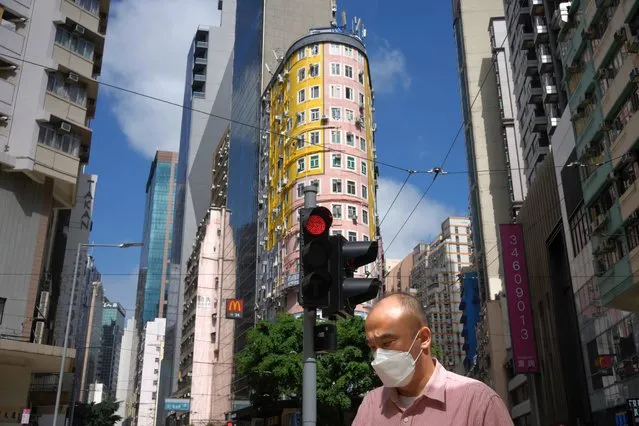 A man wearing face mask to help curb the spread of the coronavirus walks along the streets of Hong Kong, Thursday, March 31, 2022. (Photo by Vincent Yu/AP Photo)