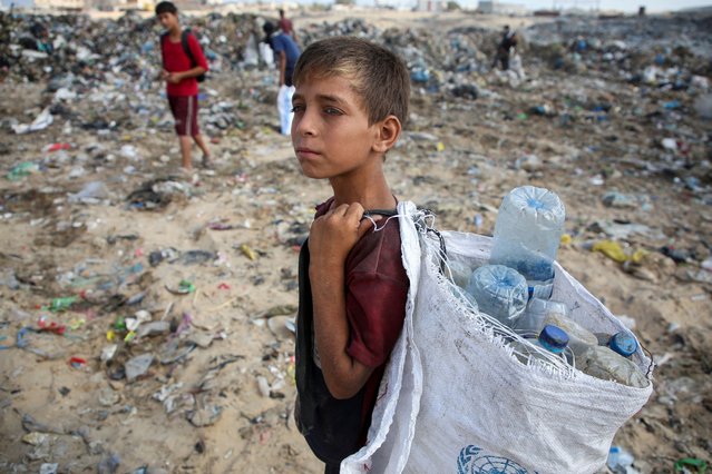 A Palestinian boy looks on as he scavenges for usable items at a dump site, amid the Israel-Hamas conflict, in Khan Younis in the southern Gaza Strip on July 15, 2024. (Photo by Hatem Khaled/Reuters)