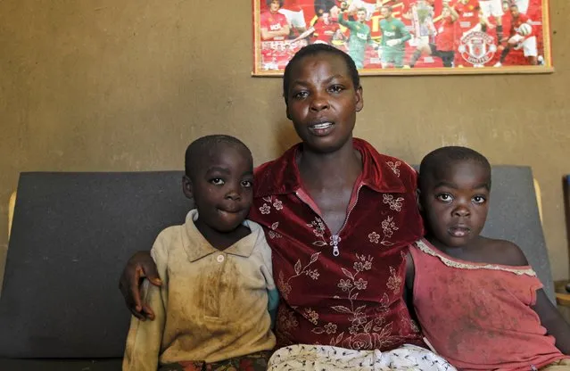 Mary Adhiambo, 25, poses with her twin daughters Faith Atieno (R) and Mercy Atieno (L) inside her house in Kogelo, west of Kenya's capital Nairobi, July 15, 2015. Adhiambi said, “We received grants to build houses and shelter from the harsh weather as an indirect benefit from President Obama's leadership”. (Photo by Thomas Mukoya/Reuters)