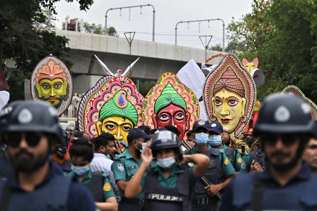 People march along a street to celebrate the Bengali New Year or “Pohela Boishakh” in Dhaka on April 14, 2022. (Photo by Munir Uz Zaman/AFP Photo)