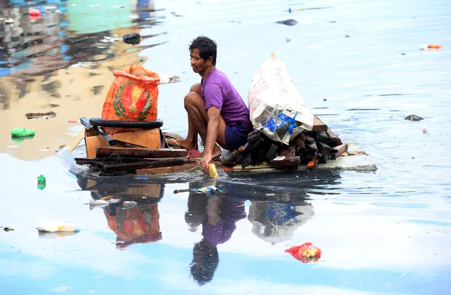 A man uses an improvised banca to collect plastic materials in a polluted river in Manila, Philippines December 24, 2016. (Photo by Romeo Ranoco/Reuters)