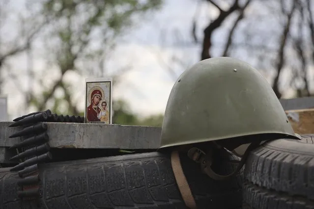An icon stands next to a military helmet at a check point in Mariupol, in territory under the government of the Donetsk People's Republic, eastern Ukraine, Wednesday, May 4, 2022. (Photo by Alexei Alexandrov/AP Photo)