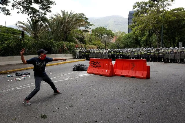 A demonstrator attempts to throw a stone towards riot police officers during a protest called by university students against Venezuela's government in Caracas, Venezuela, June 9, 2016. (Photo by Carlos Garcia Rawlins/Reuters)