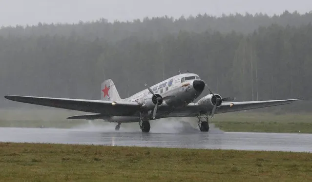Russian and U. S. crew members aboard a  U.S. Douglas C-47 Dakota military transport airplane constructed in the early 1940s, lands amidst heavy rain after a transcontinental flight on the Alaska-Siberia route, at Yemelyanovo International Airport outside the Siberian city of Krasnoyarsk, Russia, August 4, 2015. (Photo by Ilya Naymushin/Reuters)