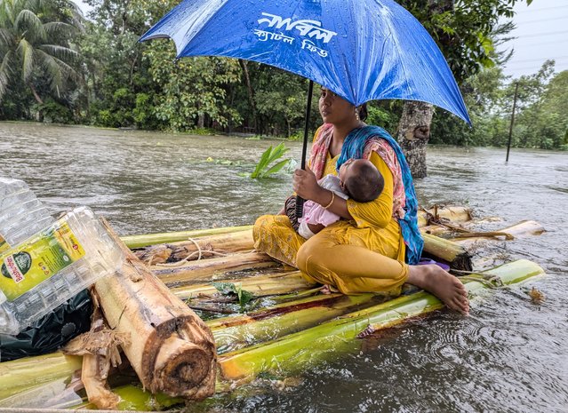 A woman and her child wade through flood waters in Feni on August 22, 2024. Floods triggered by torrential rains have swamped a swath of low-lying Bangladesh, disaster officials said on August 22, adding to the new government's challenges after weeks of political turmoil. (Photo by Zakir Hossain Chowdhury/AFP Photo)