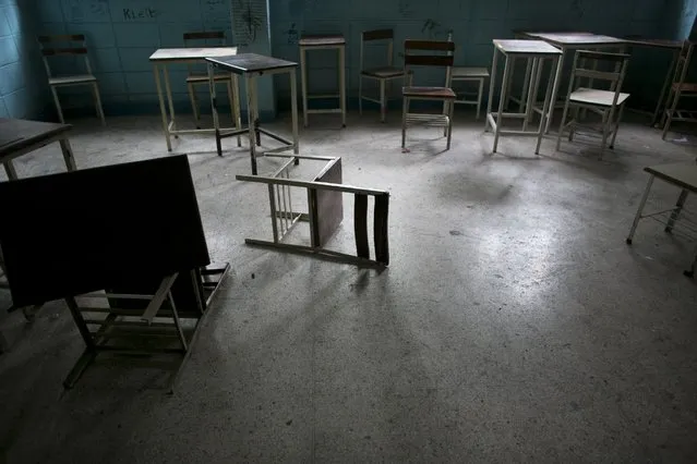 In this June 1, 2016 photo, desks and chairs sit in an abandoned classroom at a public high school in Caracas, Venezuela. Officially, Venezuela canceled 16 school days this year, including Friday classes because of an energy crisis. In reality, Venezuelan children are now missing an average of 40 percent of class time, a parent group estimates, and a third of teachers skip work on any given day to wait in food lines. (Photo by Ariana Cubillos/AP Photo)